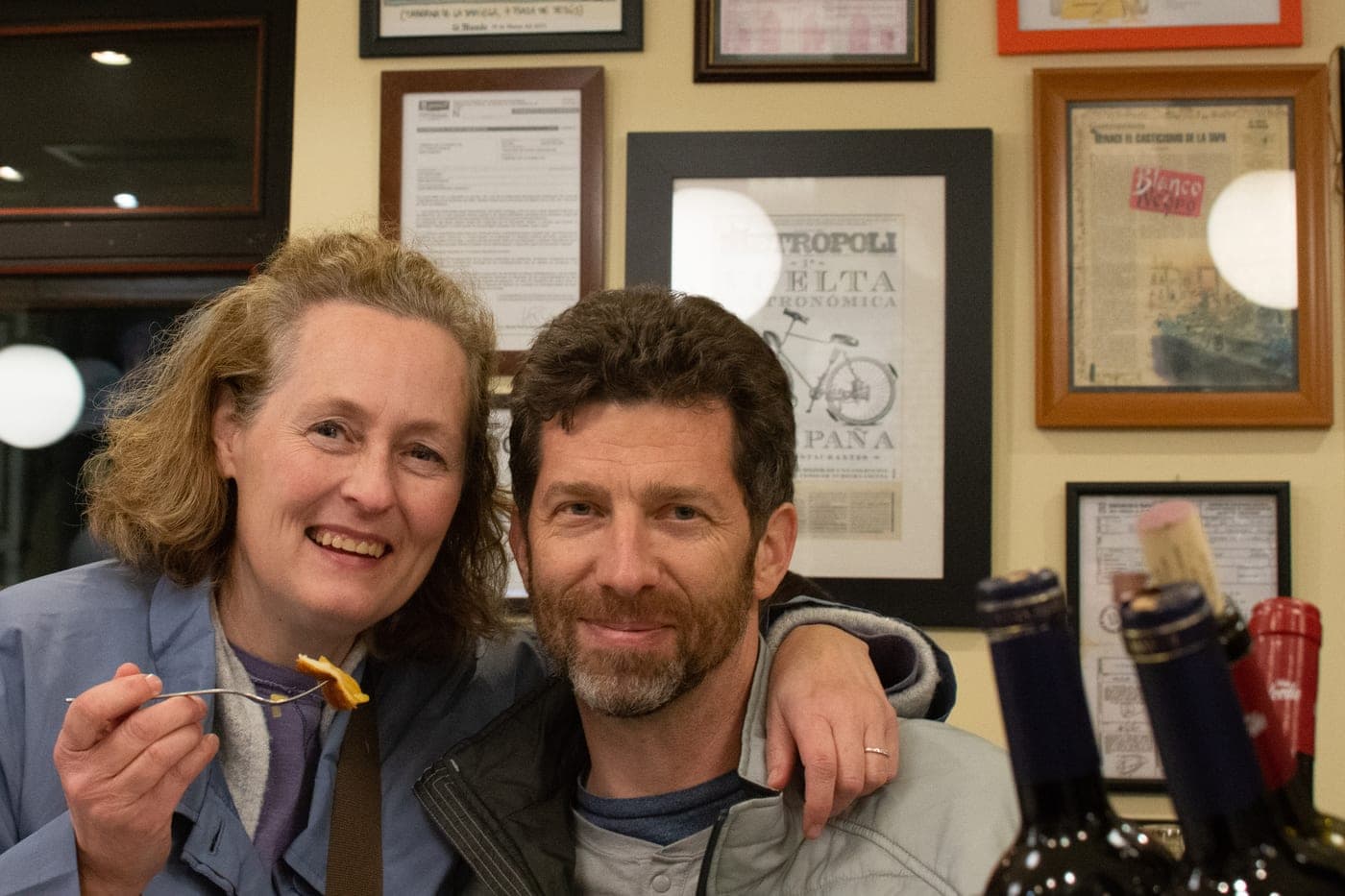 Brandon and Anne at a tapas bar in Madrid, surrounded by framed press clippings